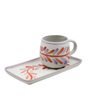 Ceramic mug with floral design on a matching tray on a white background Ceramic mug with floral design on a matching tray on a white background