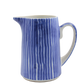 Blue and white striped ceramic pitcher on a white background
