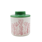 Small container with floral design and green lid on a white background
