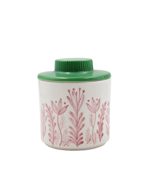 Small container with floral design and green lid on a white background