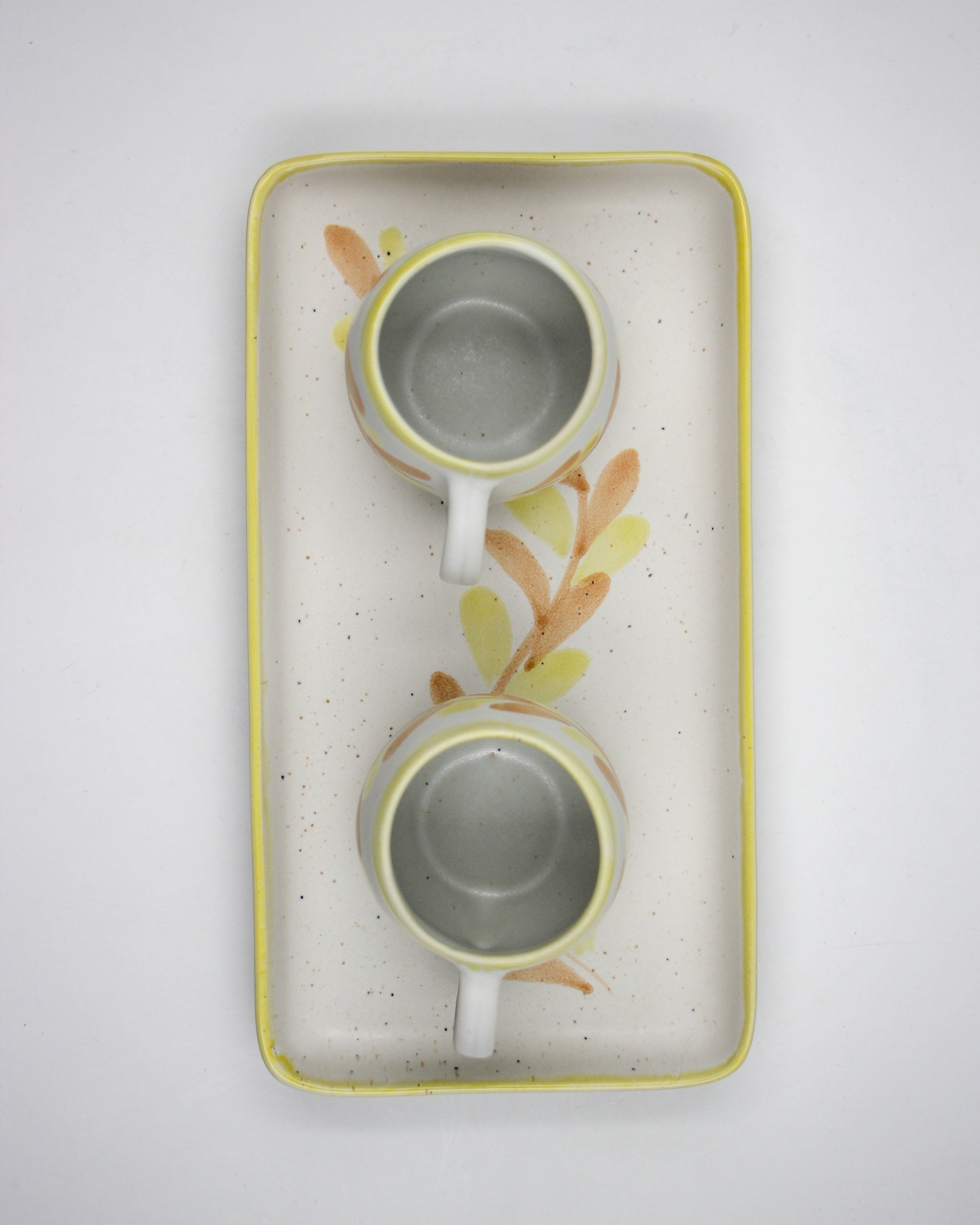 Two ceramic cups with floral design on a white background