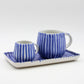 Two blue and white striped ceramic mugs with a matching tray on a light gray background