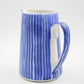 Blue and white striped pitcher on a white background