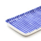 Rectangular ceramic tray with blue wavy pattern on a white background