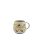 Ceramic mug with leaf pattern on a white background