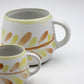 Two ceramic mugs with floral patterns on a white background