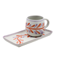 Ceramic mug with floral design on a matching tray on a white background