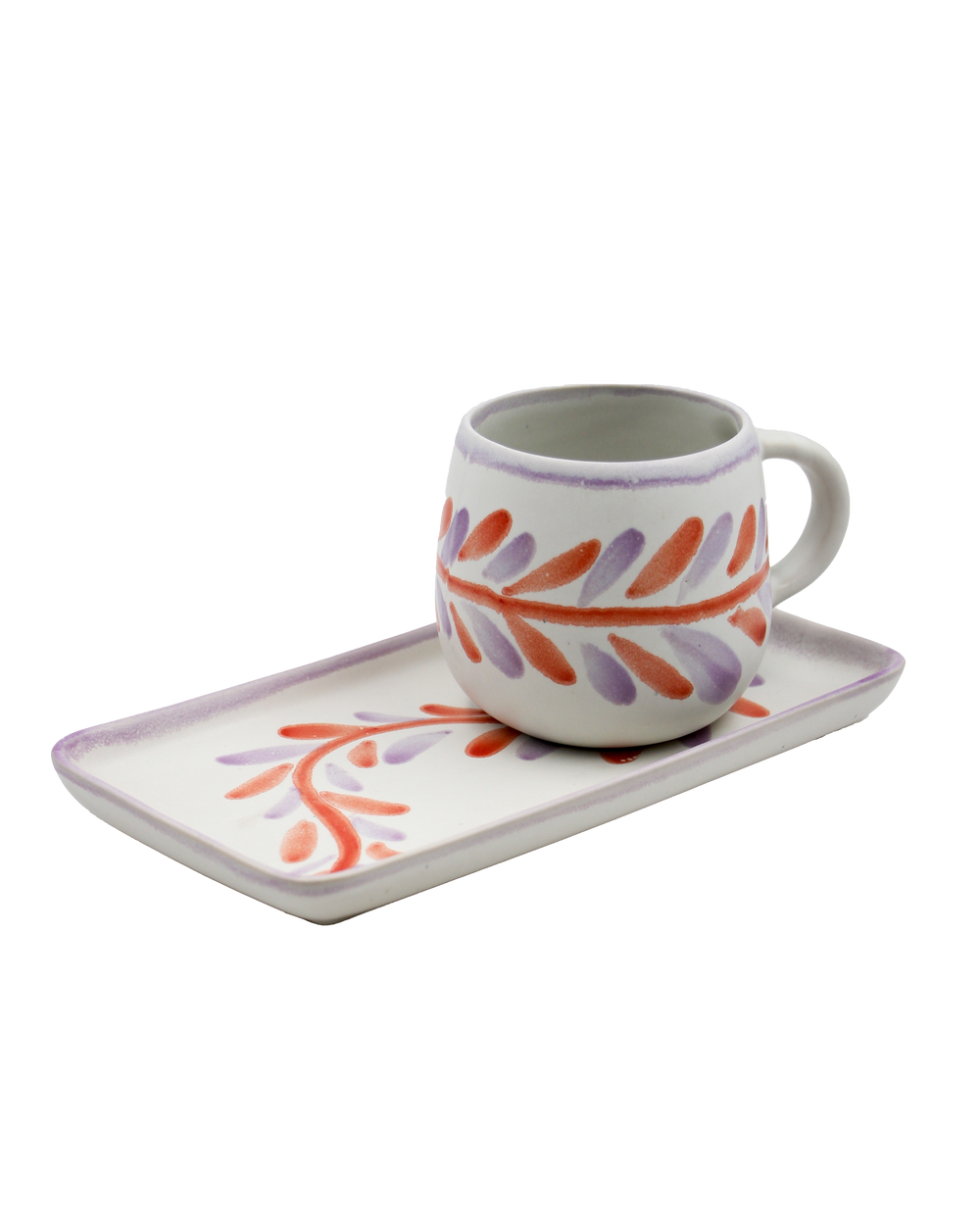 Ceramic mug with floral design on a matching tray on a white background