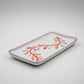 Rectangular ceramic tray with floral design on a light gray background