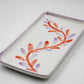 Rectangular ceramic tray with red and purple leaf design on a white background