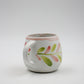 White ceramic mug with floral design on a light gray background