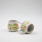 Two ceramic mugs with floral designs on a white background