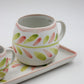 Ceramic mug with floral design on a white tray