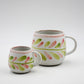Two ceramic mugs with floral patterns on a white background